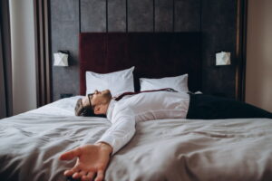 Exhausted businessman resting in bed due to jet lag